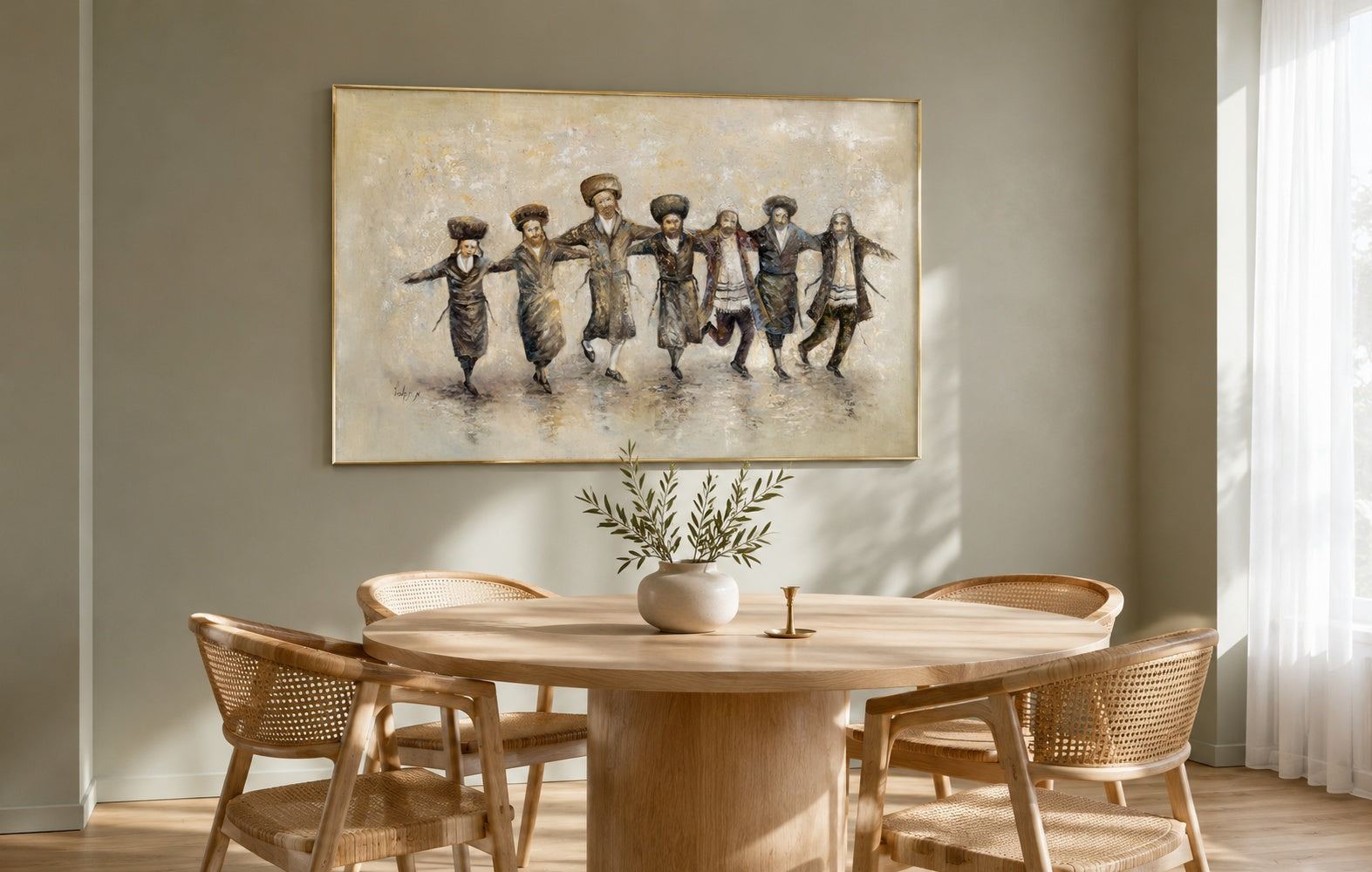 Framed painting of dancing Hasidic Jewish men in sepia and black, brass floater frame above a round oak dining table in a sage minimalist dining room.